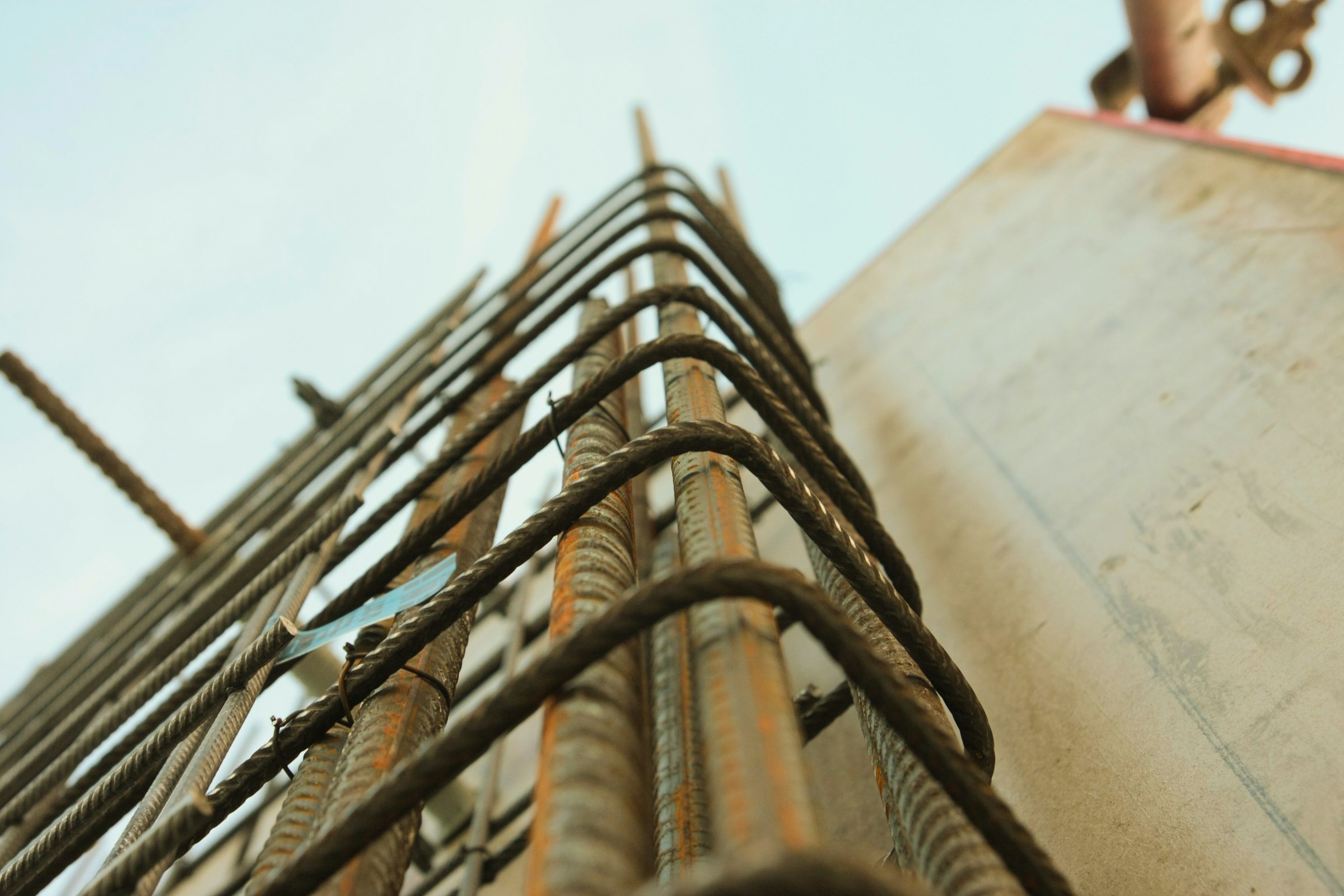 Worm's-eye view of rebar reaching skyward at a construction site